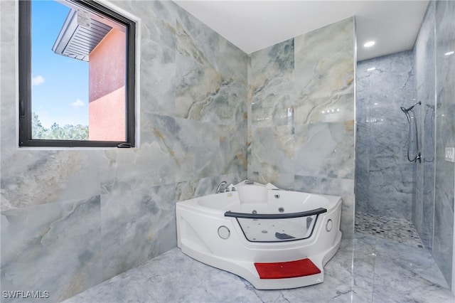 bathroom featuring tile walls and separate shower and tub