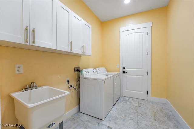 washroom with separate washer and dryer, sink, and cabinets