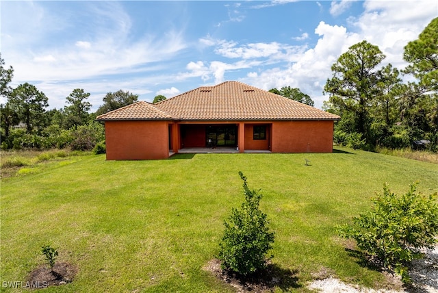 back of house featuring a yard and a patio area