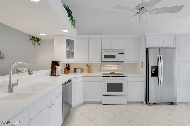 kitchen with ceiling fan, sink, white cabinetry, appliances with stainless steel finishes, and vaulted ceiling