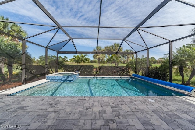 view of pool featuring a pool with connected hot tub, glass enclosure, and a patio