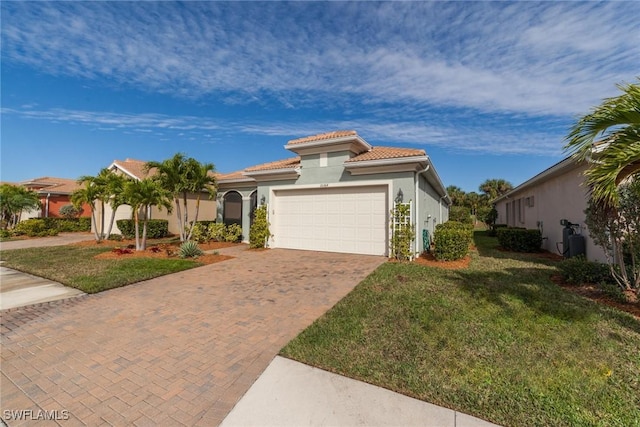 mediterranean / spanish-style home featuring a garage, a tile roof, decorative driveway, a front yard, and stucco siding