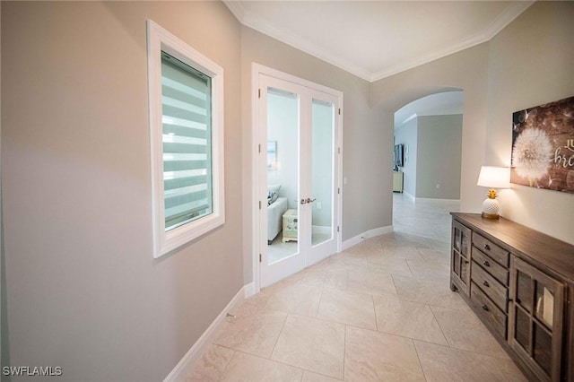 hallway featuring arched walkways, french doors, crown molding, light tile patterned floors, and baseboards