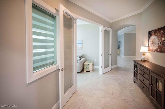 hallway with arched walkways, light tile patterned flooring, baseboards, french doors, and ornamental molding