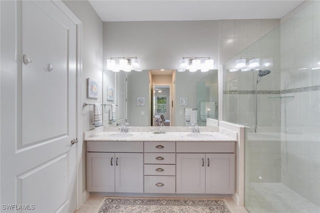 bathroom featuring double vanity, a stall shower, a sink, and connected bathroom