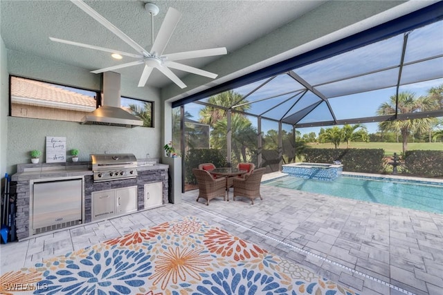 view of swimming pool with a pool with connected hot tub, a patio, exterior kitchen, and area for grilling