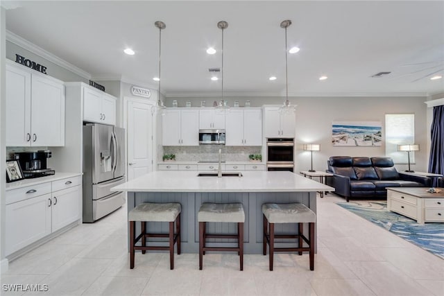 kitchen featuring stainless steel appliances, light countertops, decorative light fixtures, and white cabinets