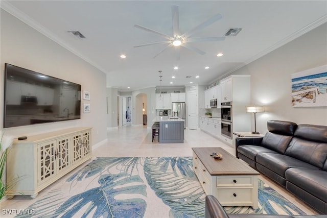 living area with visible vents, arched walkways, baseboards, ornamental molding, and recessed lighting