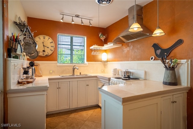 kitchen with white stove, sink, white cabinets, island range hood, and hanging light fixtures