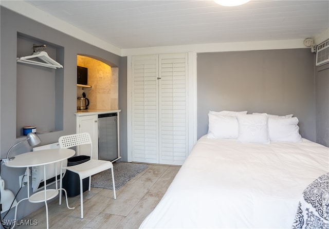 bedroom with light wood-type flooring and stainless steel fridge