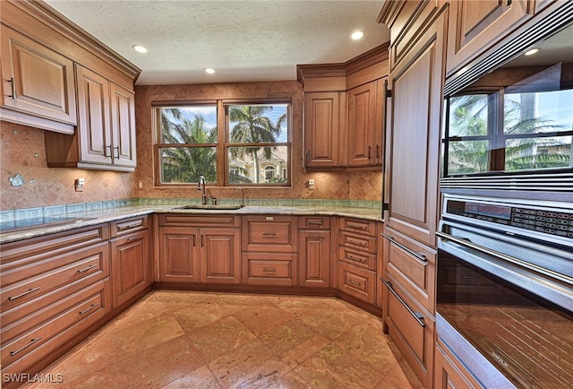 kitchen with plenty of natural light, sink, backsplash, and light stone counters