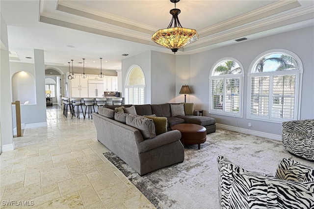 living room featuring ornamental molding and a raised ceiling