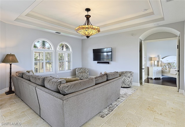 living room with crown molding and a raised ceiling