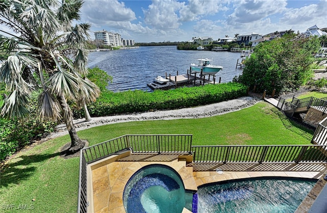 exterior space with a water view, a lawn, and an in ground hot tub