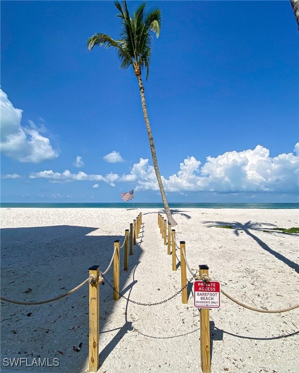 view of dock with a view of the beach and a water view