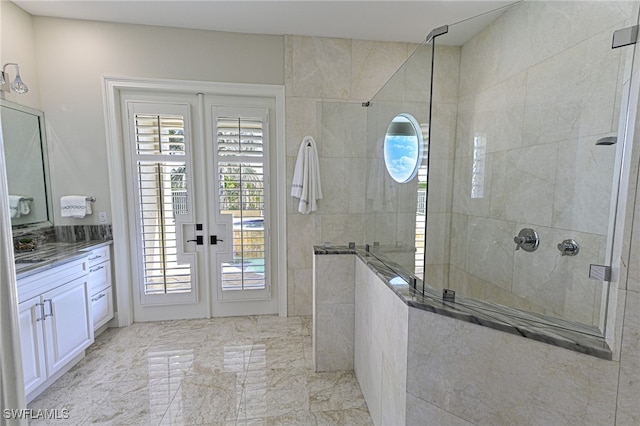 bathroom with french doors, vanity, and a tile shower