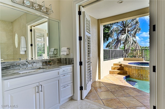 bathroom featuring tiled bath and vanity