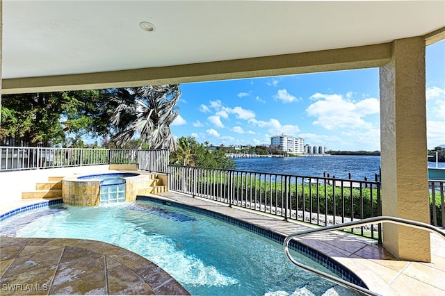 view of swimming pool with a patio area, a water view, pool water feature, and an in ground hot tub