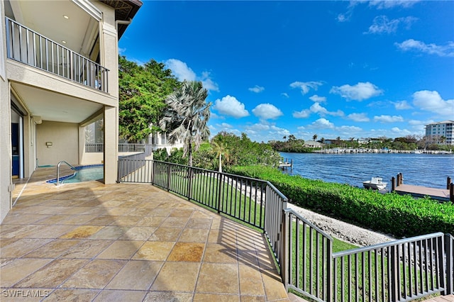 view of patio with a water view and a balcony