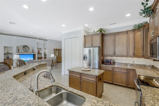 kitchen with sink, built in shelves, a kitchen island, light stone counters, and stainless steel appliances