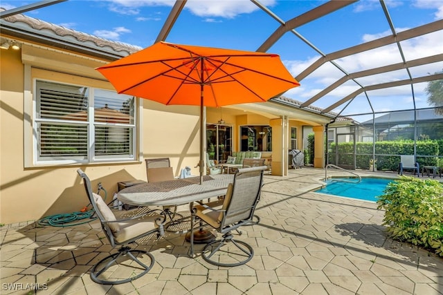 view of pool with glass enclosure and a patio