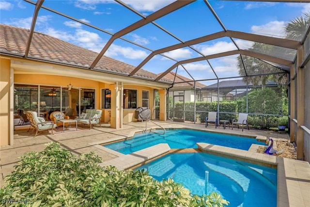 view of swimming pool featuring an in ground hot tub, a patio, ceiling fan, and a lanai