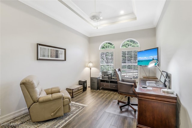 office with ceiling fan, a raised ceiling, wood-type flooring, and ornamental molding