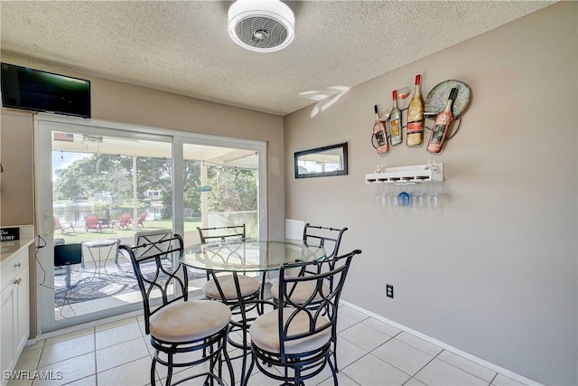 dining space featuring a textured ceiling and light tile patterned floors