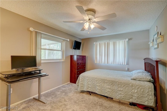 bedroom featuring ceiling fan, a textured ceiling, and light carpet