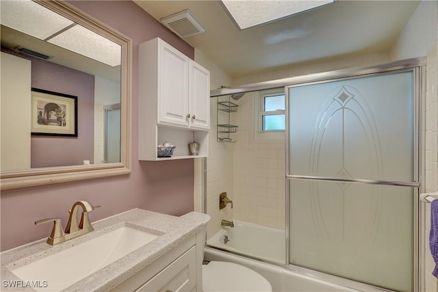 full bathroom with toilet, vanity, and bath / shower combo with glass door