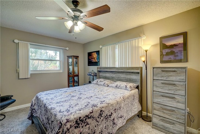 carpeted bedroom with ceiling fan and a textured ceiling