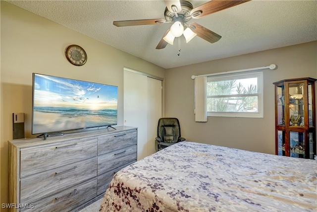 bedroom featuring a textured ceiling, ceiling fan, and a closet