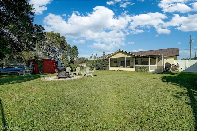 view of yard with a sunroom, a fire pit, and a storage unit