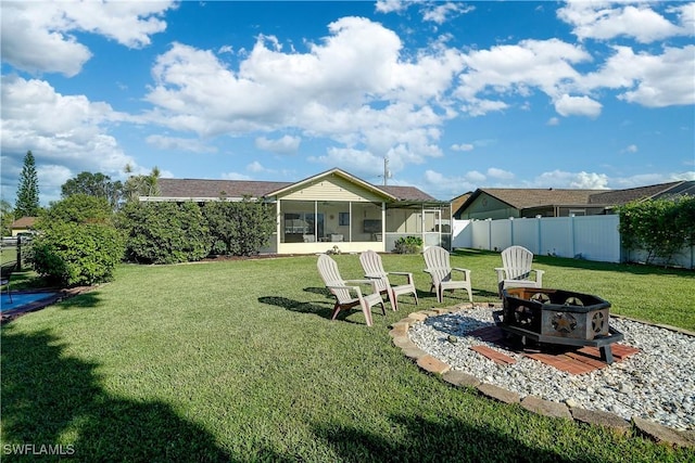 view of yard with a sunroom and a fire pit