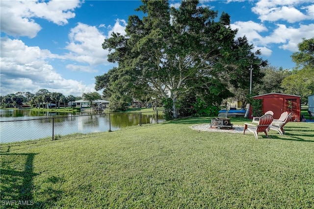 view of yard with an outdoor fire pit and a water view