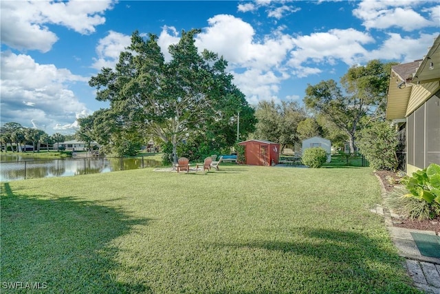 view of yard with a water view and a storage shed