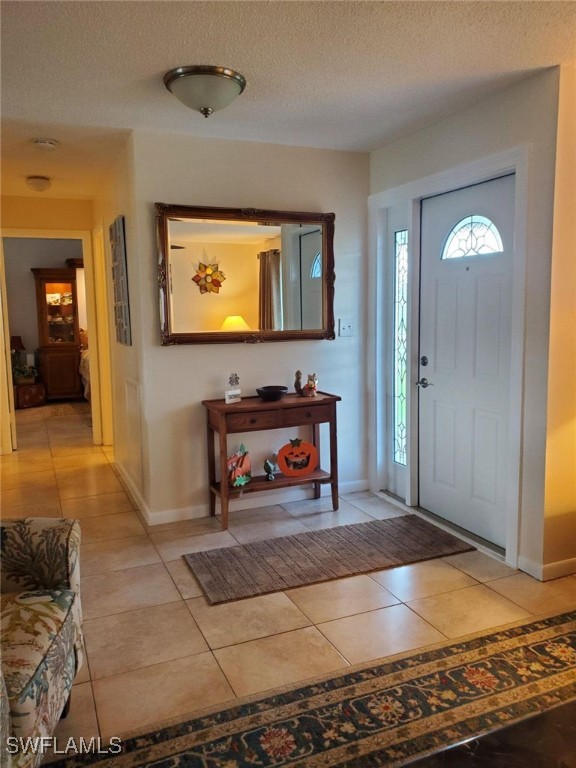 tiled foyer entrance featuring a textured ceiling