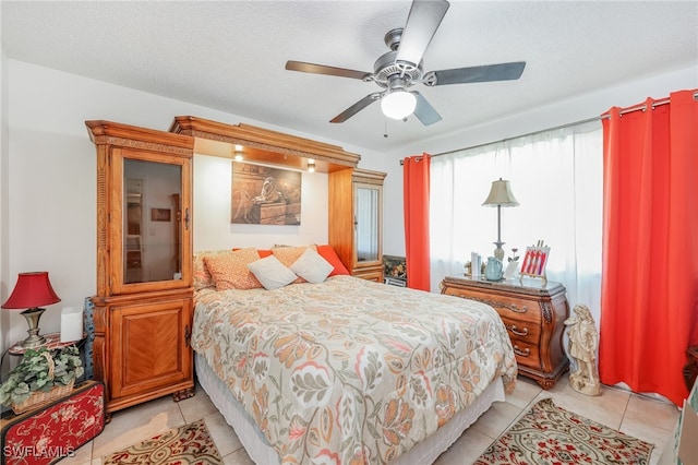 tiled bedroom with ceiling fan and a textured ceiling