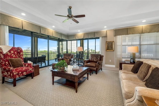 living room with crown molding, a raised ceiling, and ceiling fan