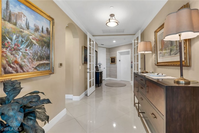 hall featuring crown molding, light tile patterned floors, and french doors