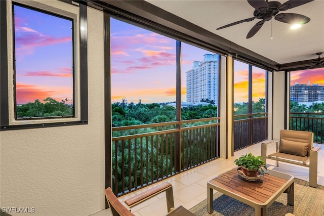 sunroom featuring a city view and ceiling fan