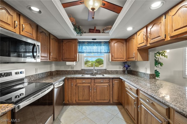 kitchen featuring dark stone countertops, light tile patterned floors, sink, and appliances with stainless steel finishes