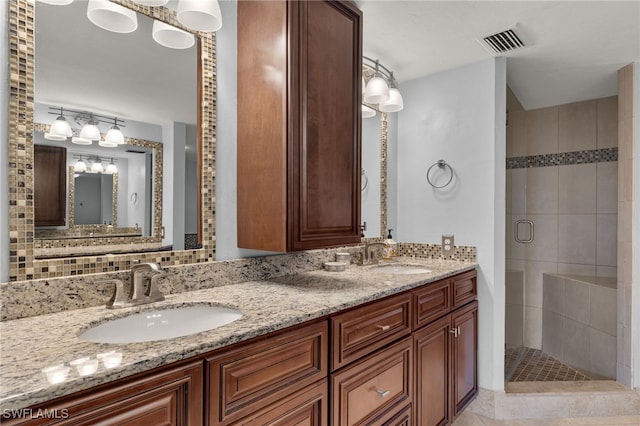 bathroom with tile patterned flooring, vanity, tasteful backsplash, and an enclosed shower