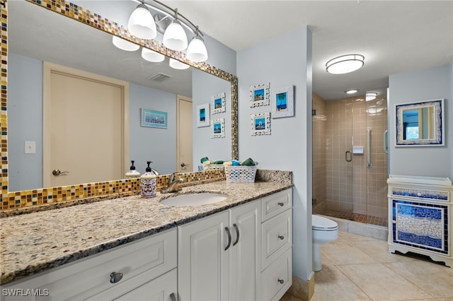 bathroom with tile patterned floors, vanity, an enclosed shower, and toilet