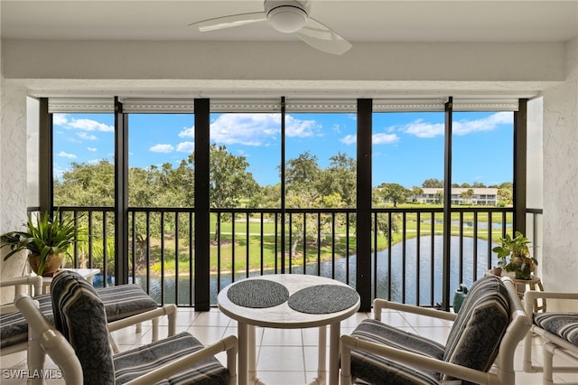 sunroom / solarium with a water view, plenty of natural light, and ceiling fan