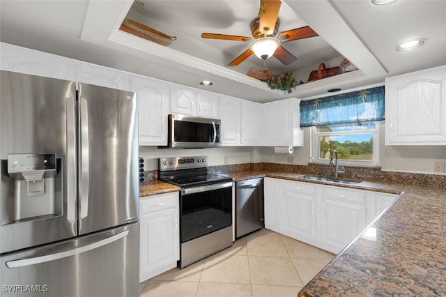 kitchen with white cabinets, sink, a raised ceiling, and stainless steel appliances