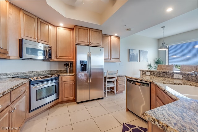 kitchen featuring sink, stainless steel appliances, pendant lighting, light stone counters, and light tile patterned floors