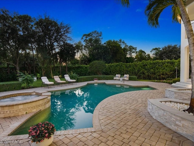 view of swimming pool featuring a pool with connected hot tub and a patio