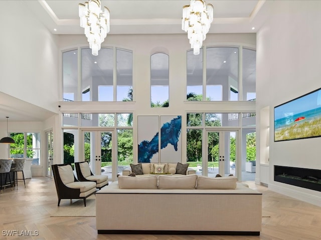 living room with light parquet floors, an inviting chandelier, and french doors