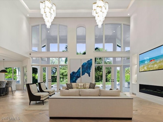 living area featuring a notable chandelier, a high ceiling, and french doors